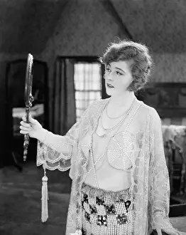 Intent: Woman looking in hand mirror
