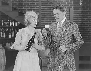 Displeased: Woman looking at man making faces while tasting