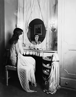 Vanities: Woman looking in mirror at dressing table