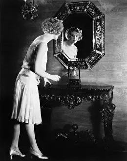 Consoling: Woman looking into a mirror about to ring a bell