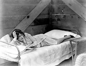 Cots: Woman lying on cot reading