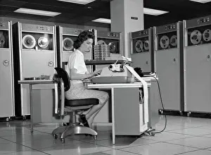 High Tech: Woman in mainframe computer room surrounded by