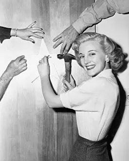 Nailing: Woman nailing up star with helping hands