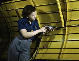 Repairing: Woman operating a hand drill while working