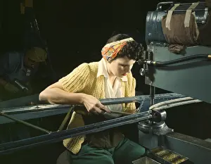 Riveter: Woman operating a riveting machine on wing of