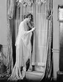 Peeking: Woman peeking out window