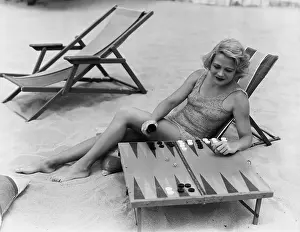 Diversion: Woman playing backgammon on beach