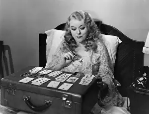 Diversion: Woman playing cards in bed