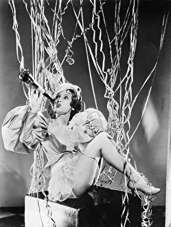 Streamer: Woman playing a horn with streamers around her