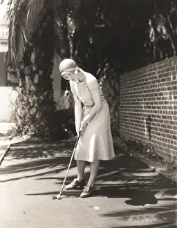 Ov1606: Woman playing miniature golf