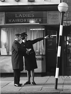 Belisha: Woman police officer giving directions on a London street