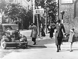 Belisha: Woman police officer guiding little girl across the road