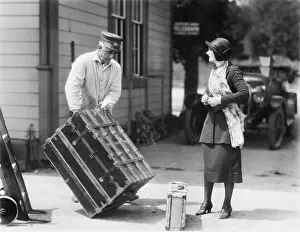 Helpful: Woman and a porter carrying her trunk
