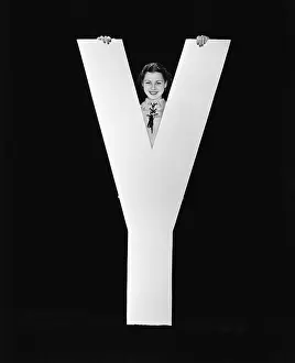 Peeking: Woman posing behind huge letter Y