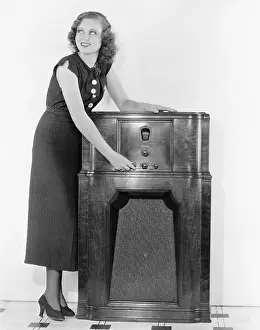 Long Haired: Woman next to a radio turning the knobs