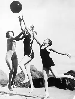 Mid Air: Three woman reaching for beach ball