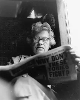 Drooping: Woman reading a newspaper on a train