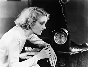 Synchronizing: Woman setting watch to clock