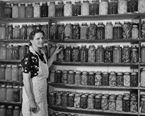 Camerique: Woman in front of shelfs full of cans of fruit and veg