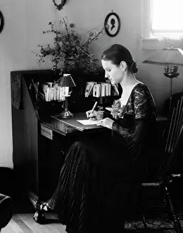 Woman Sitting at Desk Writing Letter