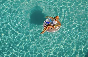 Sunning: Woman Sitting on Float in Swimming Pool