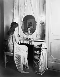 Long Haired: Woman sitting at her vanity table smiling into the mirror