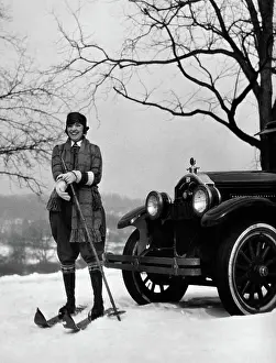 Gloved: Woman on skis standing in front of car pulling