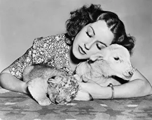 Tenderness: Woman with sleeping lamb and lion cub