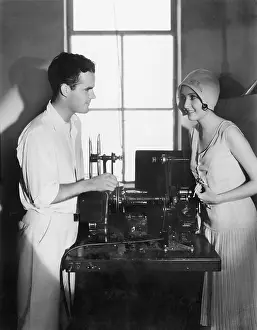Editing: Woman smiling at a man next to an editing machine