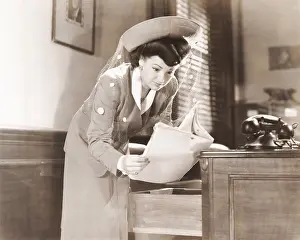 Nosy: Woman sneaking a look at documents in office