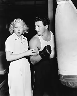 Punching: Woman standing next to a boxer feeling his arms