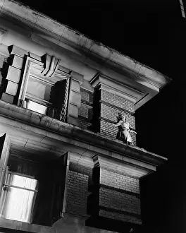 Nightfall: Woman standing on the top of a building on a ledge