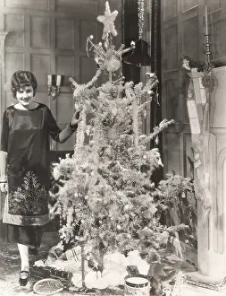 Topper: Woman standing by decorated Christmas tree