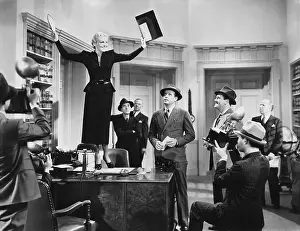 Businesswoman: Woman standing on desk announcing result