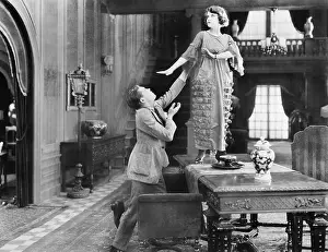 Rejection: Woman standing on a table being adored by a man