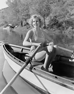 Rowboats: Woman in a striped bathing suit rowing