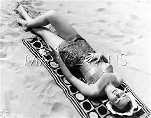 Sunbathes: A WOMAN SUNBATHING