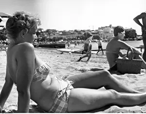 Bask: Woman sunbathing on a beach