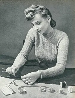 Bobbin: Woman tacking a hem before stitching it