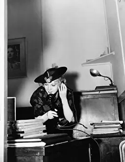 Hurried: Woman talking on phone in office