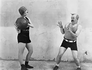 Tossing: Woman throwing ball to nervous man