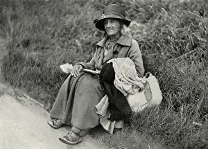 Characterful: Woman tramp sitting at side of road