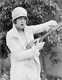 Mandolins: Woman tuning mandolin outside