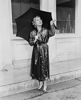 Raincoats: Woman with umbrella testing for rain