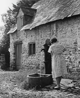 The Japics Historic Image Collection: Woman using water pump