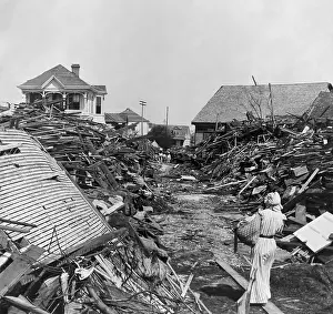 Hurricanes: A woman walks through a passageway opened in the