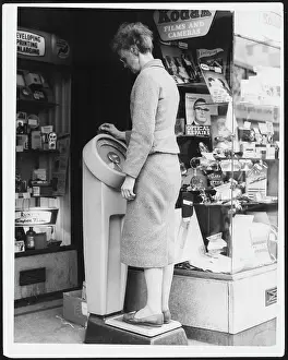 Weighs: WOMAN WEIGHING HERSELF