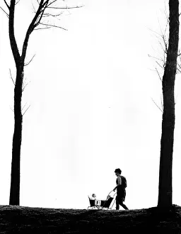 Woman wheeling two babies in a pram
