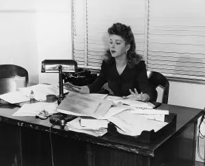 Businesswoman: Woman working at desk covered in papers