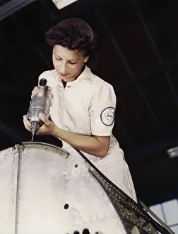Servicing: Woman working with a rivet gun, training to